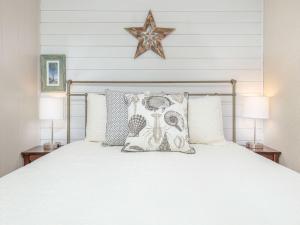 a bedroom with a white bed with two lamps at Beach Racquet B202 in Tybee Island +30 photos