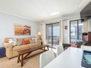 a living room with a couch and a table at Beach Racquet B202 in Tybee Island