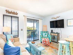 a living room with a couch and a tv at Beach Racquet A330 in Tybee Island