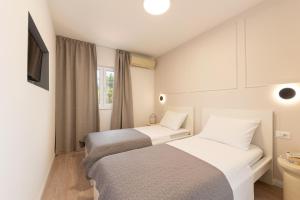 twee bedden in een kleine kamer met een raam bij Apartment Sasso in Split +61 foto's