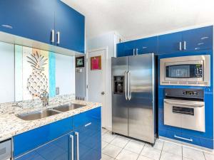 a kitchen with blue cabinets and stainless steel appliances at Beach Racquet A330 in Tybee Island