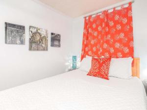 a bedroom with a bed with red and white pillows at Beach Racquet A330 in Tybee Island +30 photos