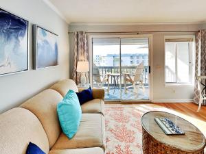 a living room with a couch and a table at Beach Racquet A301 in Tybee Island