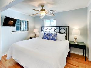 a bedroom with a white bed and a ceiling fan at Beach Racquet A301 in Tybee Island +25 photos