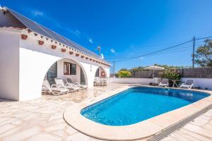 a villa with a swimming pool and a house at Villa Chiquita in Cala'n Porter