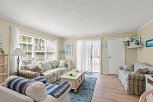 a living room with two couches and a table at The Cottages at Captain Gosnold Village in Hyannis