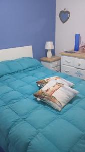 a bed with a blue comforter on top of it at Villino Gambino in Menfi