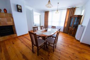 a dining room with a table with chairs and a fireplace at Dom z Widokiem in Augustów