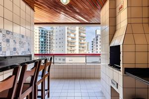 Et tv og/eller underholdning på Vila Tupi-Praia Grande , 100 metros da praia, 2 quartos com ar condicionado ,sendo uma suíte, Piscina , varanda com churrasqueira, garagem , Wi-Fi