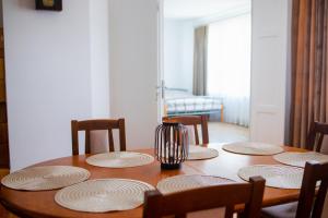 a wooden table with plates and a vase on it at Dom z Widokiem in Augustów +9 photos