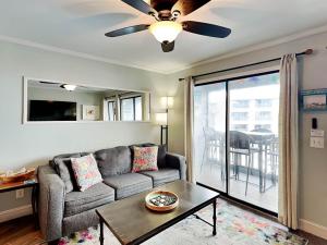 un salon avec un canapé et un ventilateur de plafond dans l'établissement Beach Racquet A209, à Tybee Island
