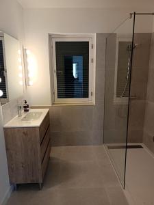 un bagno con lavandino e doccia di Petit Paradis a Son Bou Altre 6 foto