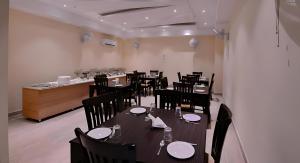 a restaurant with black tables and chairs and a counter at Grand Hridey One Minute From Railway Station in Amritsar