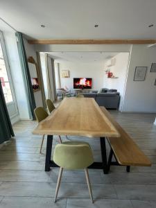 a large wooden table in a living room with a couch at Bel appartement lumineux au cœur de Bayonne in Bayonne +8 photos
