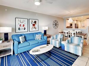 a living room with a blue couch and two chairs at Beach House 433 in Tybee Island