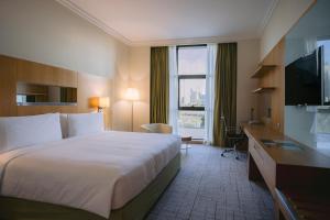 a hotel room with a large bed and a television at Holiday Inn Abu Dhabi by IHG in Abu Dhabi