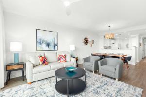 a living room with a couch and chairs and a table at Beach House 413 in Tybee Island