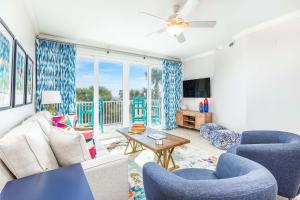 a living room with blue chairs and a table at Beach House 415 in Tybee Island