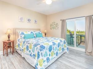 a bedroom with a bed and a balcony at Bay View Villas 107 in Tybee Island