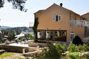 a large house with a patio in front of it at San Rocco Lumbarda in Lumbarda