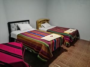 due letti uno accanto all'altro in una stanza di Illariywasi Homestay Comunidad Pueblo Isla Amantani a Ocosuyo Altre 7 foto
