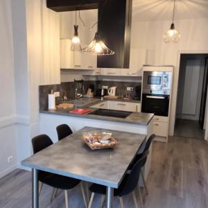 a kitchen with a table with chairs and a counter top at Maison de village au calme 4 chambres in Cuiseaux