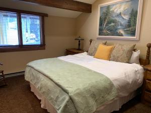 a bedroom with a large bed and a painting on the wall at Mountainback 79 Loft Den in Mammoth Lakes