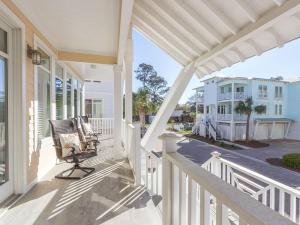 un porche con mecedora en una casa en All About Tybee, en Tybee Island