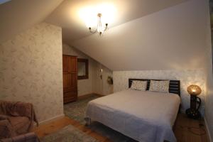 a bedroom with a bed and a chair in it at Siedlisko w Dolinie Wieprza in Giżyce Kolonia +64 photos