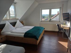HerbsteinにあるFerienwohnung Schneiderのベッドと机と2つの窓がある寝室 +19枚の写真