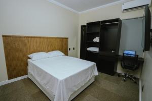 a bedroom with a bed and a desk and a television at Residência TCA in Brasilia