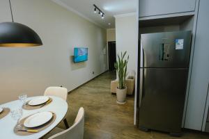 a dining room with a table and a refrigerator at Residência TCA in Brasilia