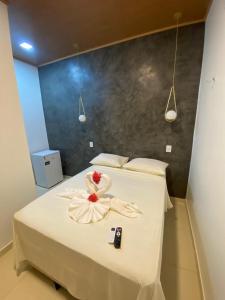 a room with a bed with a flower on it at Pousada Da Mangueira in Barreirinhas