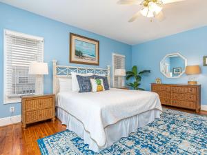 Un dormitorio con una cama y una pared azul. en 5 Oclock Somewhere, en Tybee Island