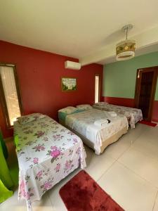 due letti in una stanza con pareti rosse di Hotel rural Santa Luzia 2 a Santa Luzia do Pará