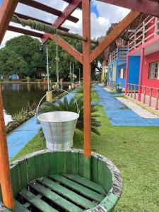 un secchio appoggiato sull'erba accanto a uno specchio d'acqua di Hotel rural Santa Luzia 2 a Santa Luzia do Pará