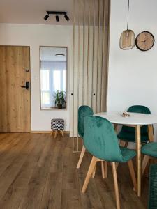 a dining room with a table and green chairs at Apartament 49 in Toruń
