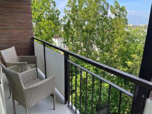 a balcony with chairs and a view of trees at Apartament 49 in Toruń
