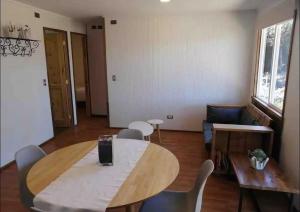 a living room with a wooden table and chairs at Cabaña aeropuerto Puerto Montt in El Tepual