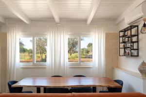 Un comedor con una mesa y dos ventanas. en Nathacasa Oria, en Oria