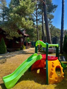 un patio de recreo con un tobogán en un parque en Domki MAYAmi, en Bobolin