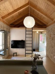 a living room with a ladder and a tv and a ceiling at Stonehouse Zrmanja in Obrovac