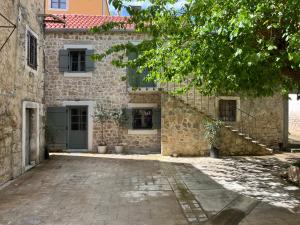 an old stone house with stairs in front of it at Stonehouse Zrmanja in Obrovac