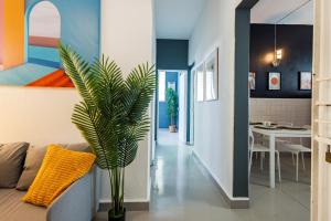 a living room with a couch and a potted plant at Spanish Lagoon San Juan with Private Patio by PH in San Juan