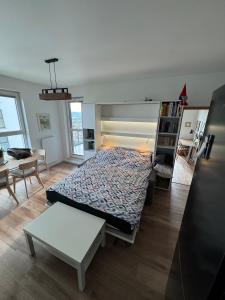 a bedroom with a bed and a table in it at Navy Blue Apartment in Gdynia