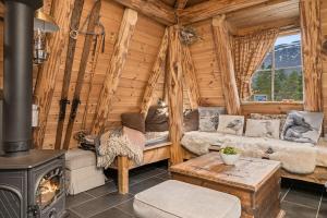 een woonkamer in een blokhut met een houtkachel bij Unique Hobbit Cabin By Hallingskarvet in Hovet