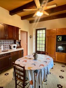 a kitchen with a table with a vase on it at Superbe gîte à la campagne avec grand jardin et spa privé in Vernet-le-Bas +17 photos