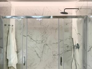 a bathroom with a shower with a glass door at Suite with Private Courtyard - Colosseum & Forum in Rome