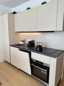 a kitchen with white cabinets and a black counter top at Suite with Private Courtyard - Colosseum & Forum in Rome