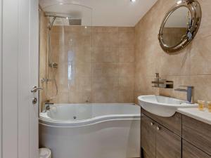 a bathroom with a tub and a sink and a mirror at 2 Bed in Westward Ho 45753 in Northam